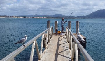 Man and daughter fishing at Cooktown Wharf
