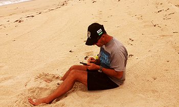 Chris sitting on beach injured